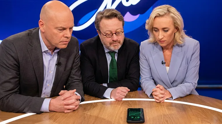 Mensen met borden voor De Hallen, ochtendlicht